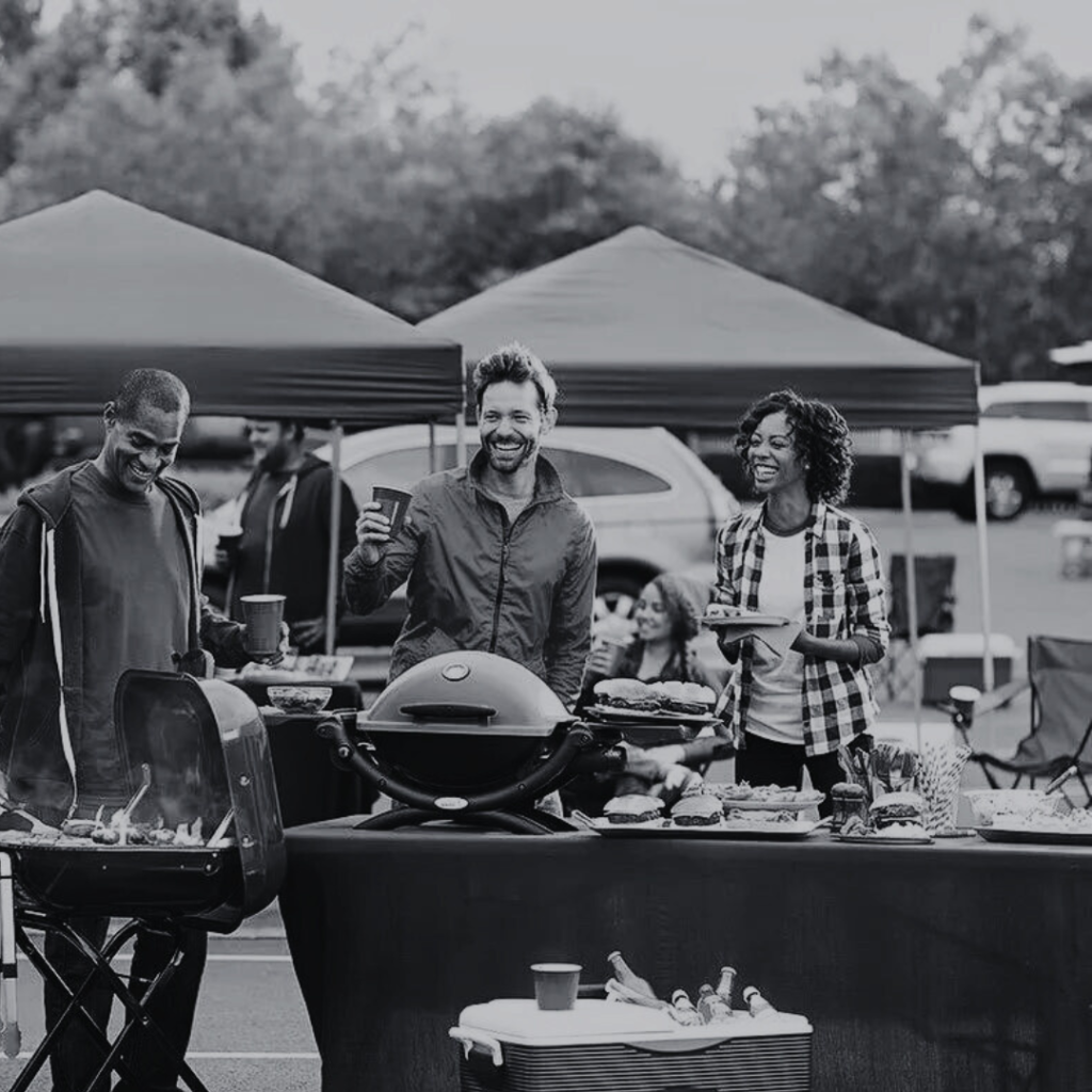 Group enjoying outdoor barbecue event together.